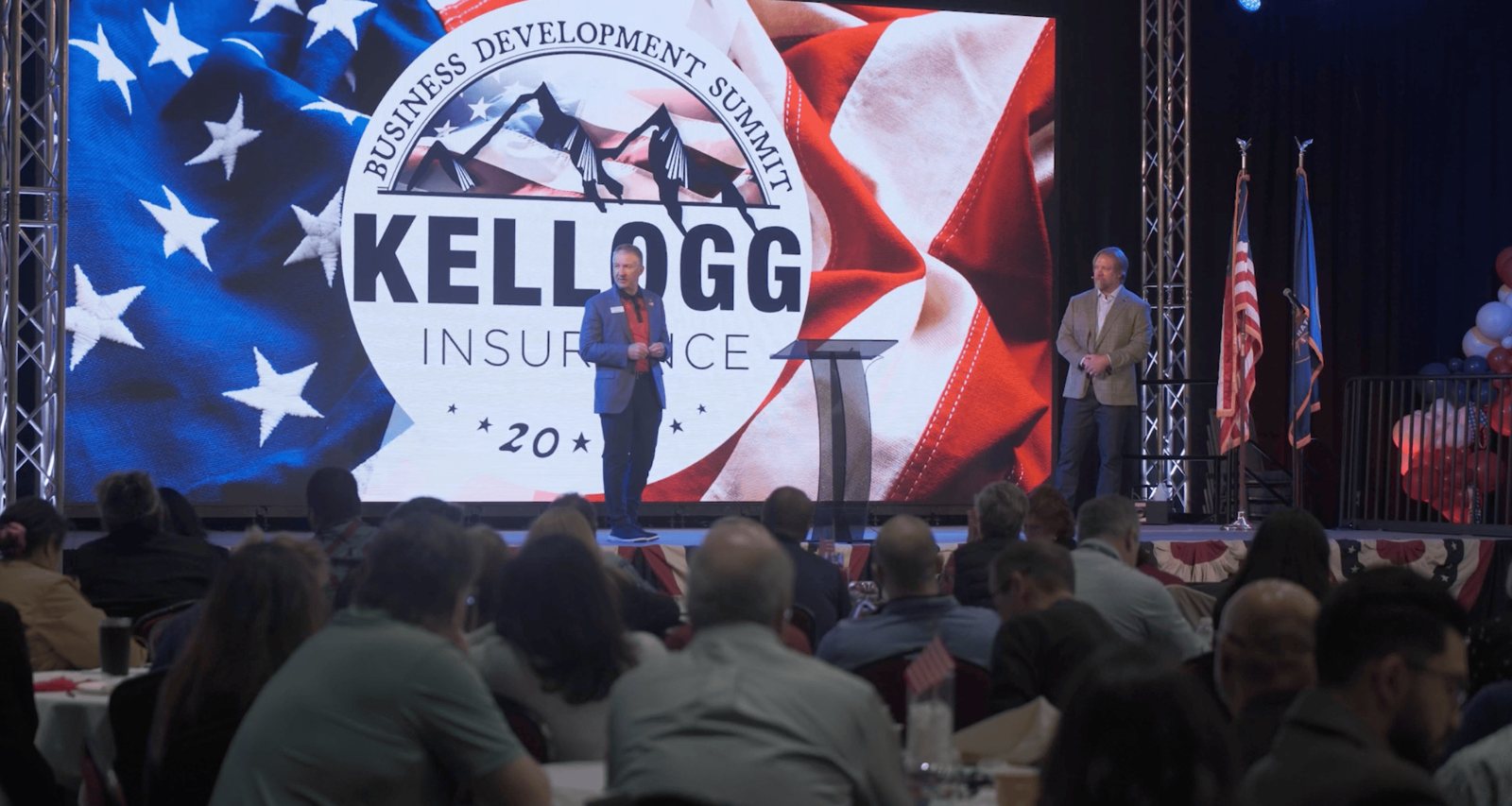 Kellogg Business Development Summit general session in front of the branded LED wall