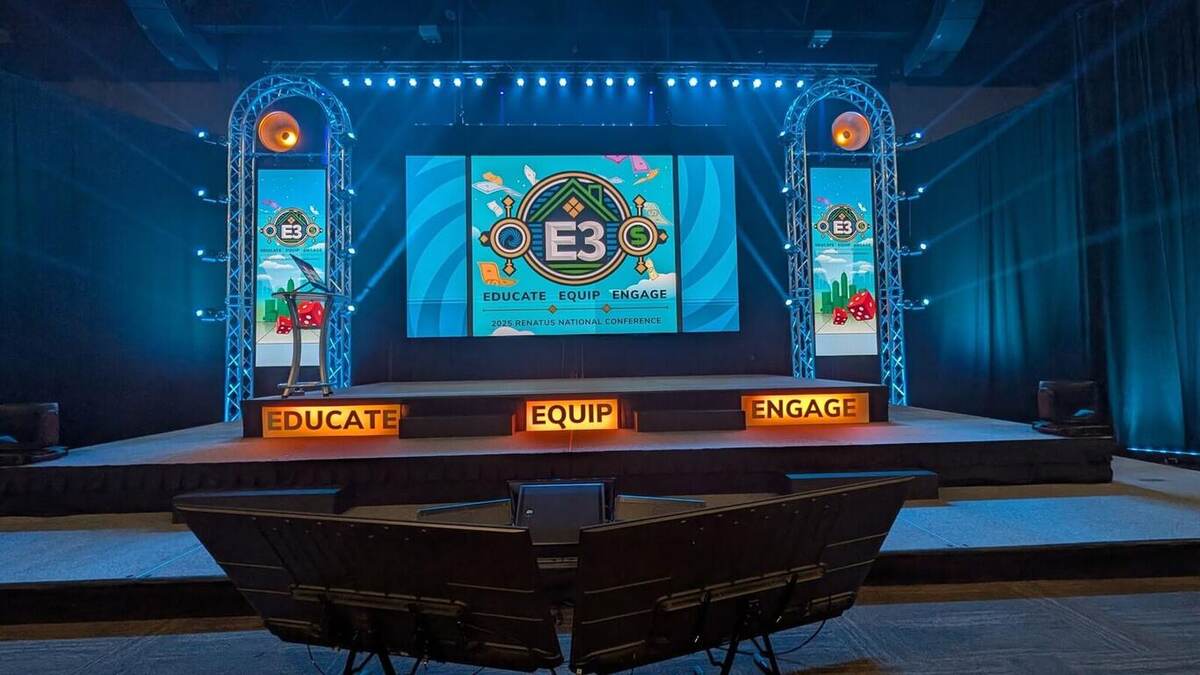 A symmetric conference stage with dual LED screens and truss towers