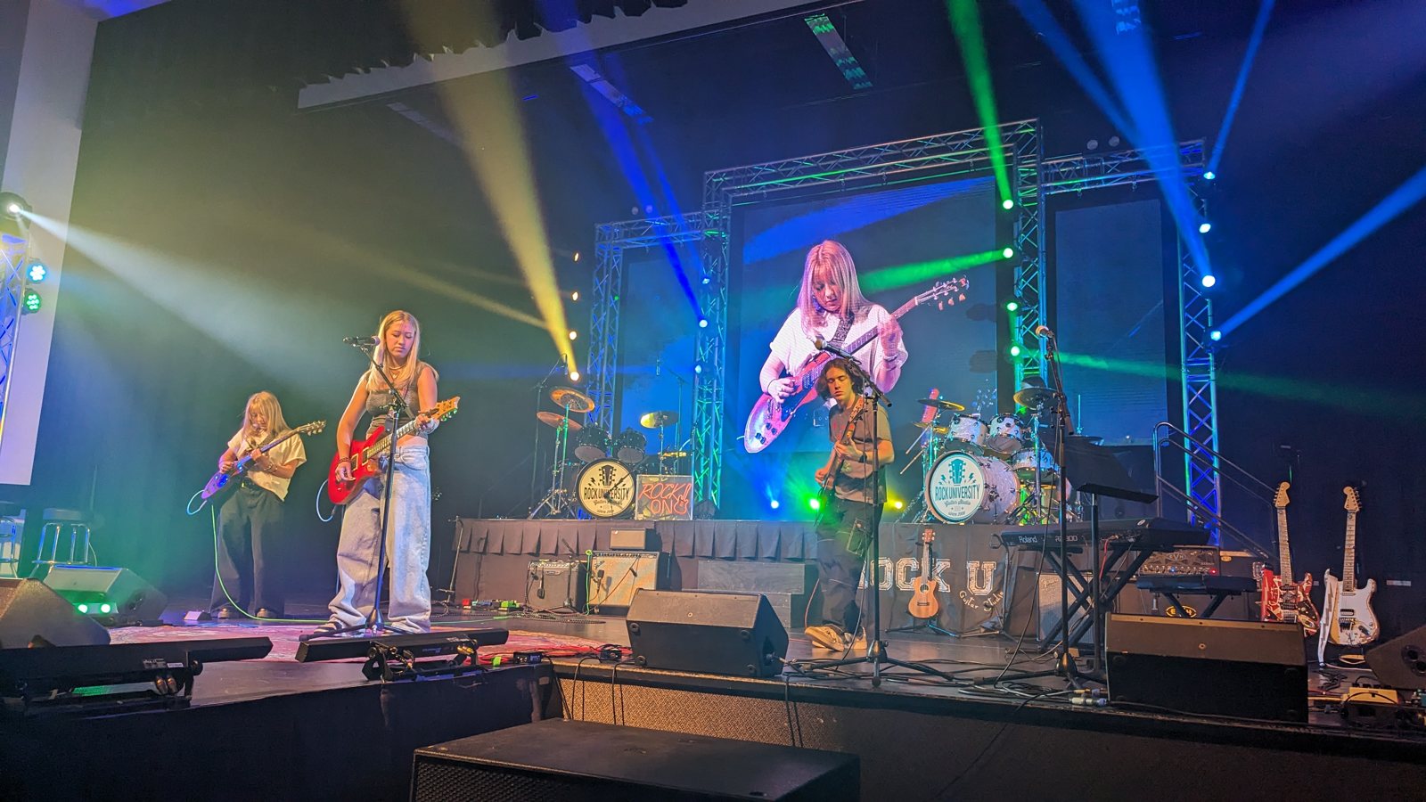A student band performing with full stage lighting and LED