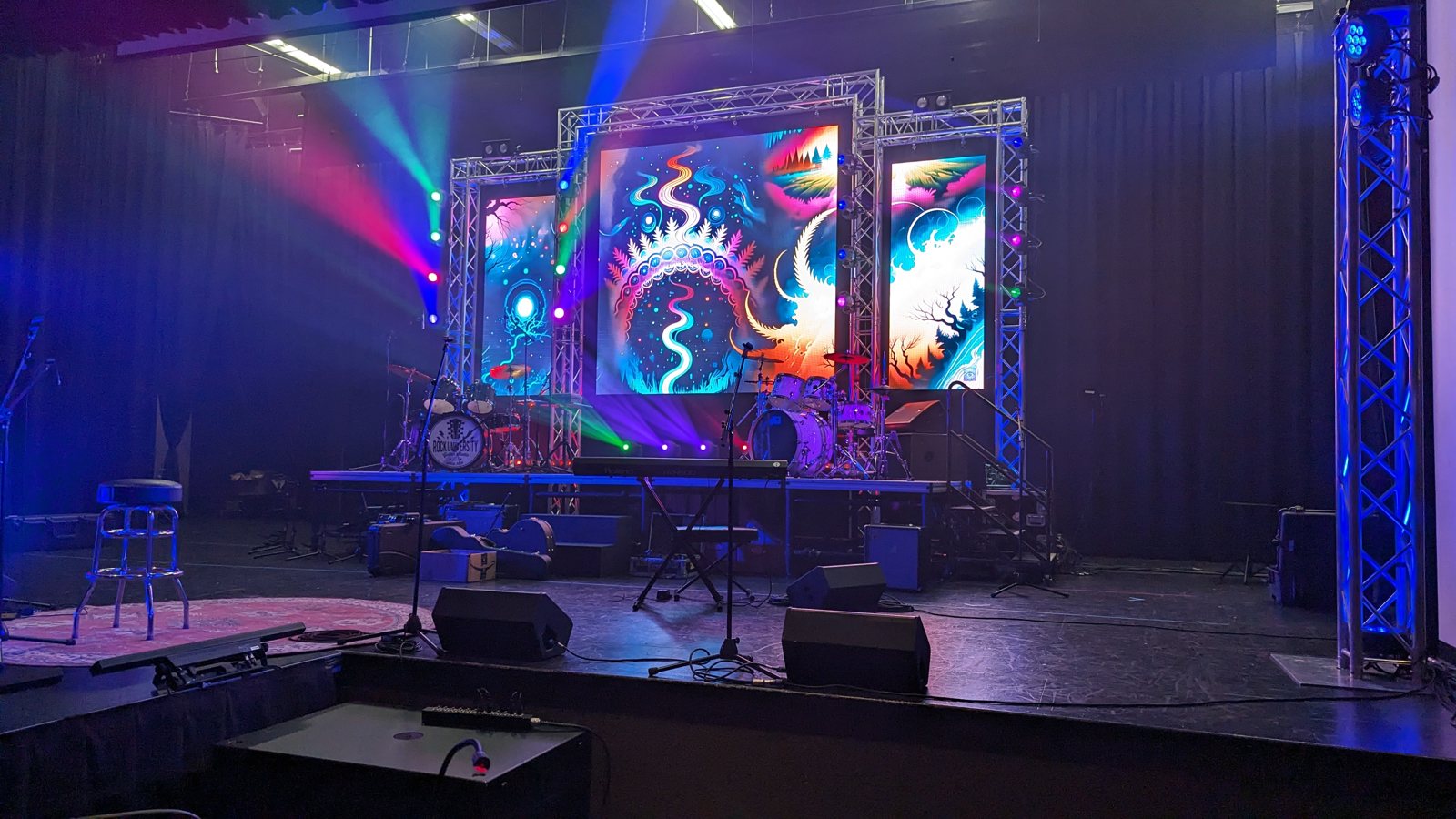 A fully built concert stage with LED screens and a lighting rig